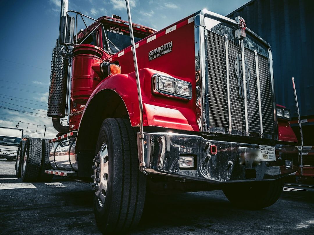 Ein roter Kenworth Lkw aus einer Froschperspektive vor blauem Himmel.
