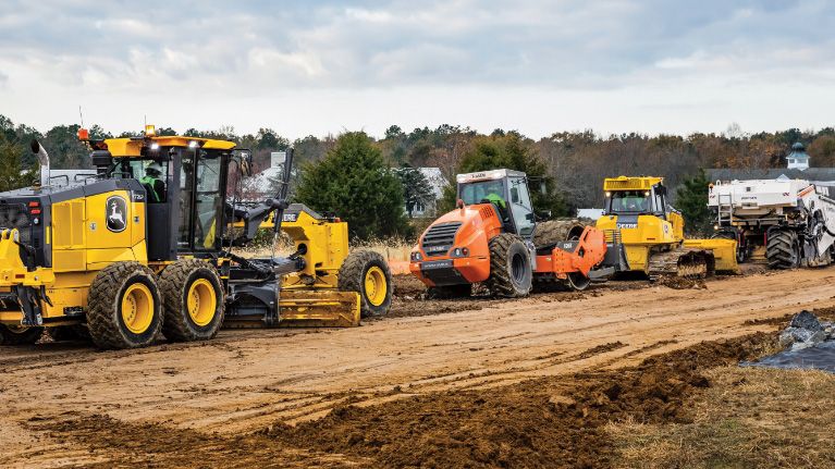 Schwere Baumaschinen und Nutzfahrzeuge auf einer Erdbaustelle.