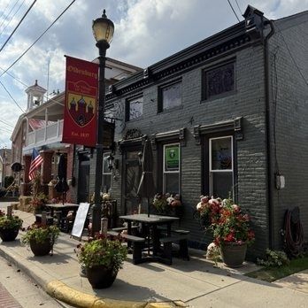 Historische Backsteinfassade mit Straßencafé und dekorativen Bannern