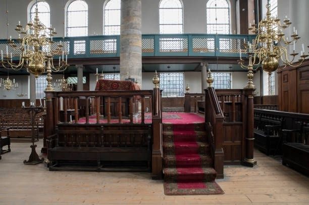 Historischer Synagogeninnenraum mit erhöhter Bima und rotem Teppich