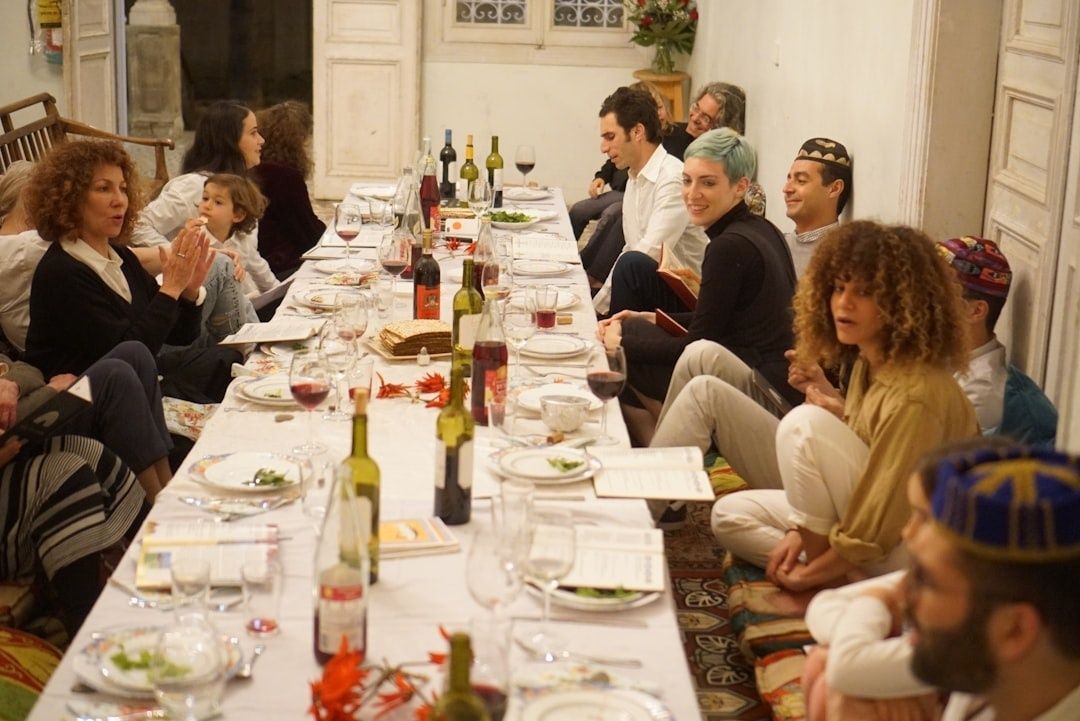Große Tischrunde beim gemeinsamen Essen mit Wein und festlicher Atmosphäre